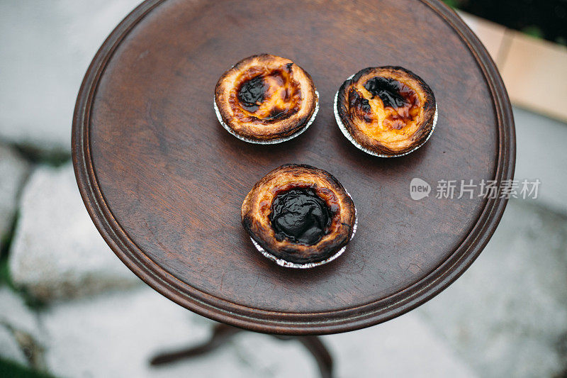 柔和的de nata。传统的葡萄牙蛋糕放在古老的木桌上